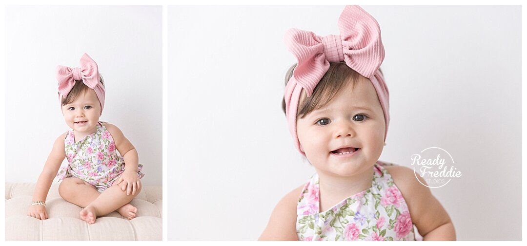 One year old girl wearing floral romper and taking birthday photos at all white and natural photography studio in Miami with Ivanna Vidal. 
