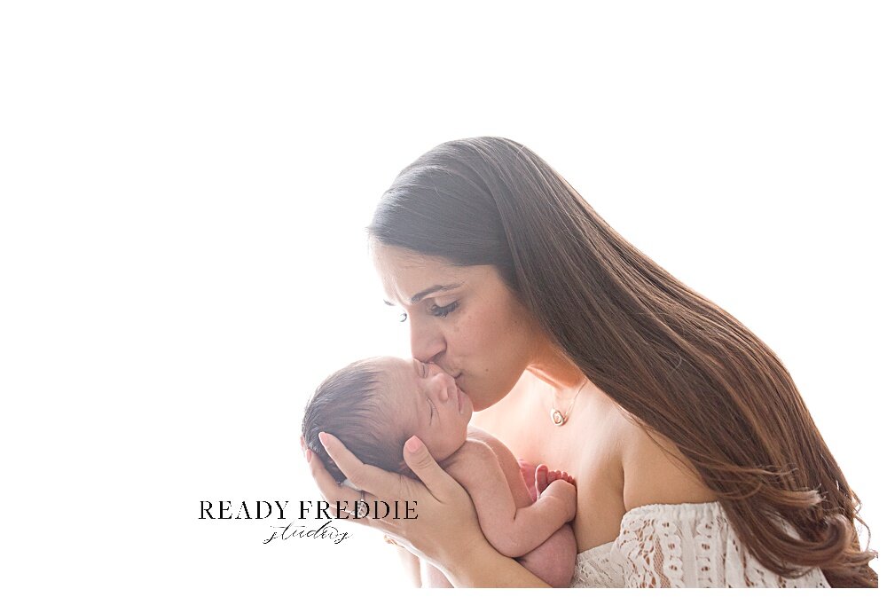 Mom kisses newborn baby boy during photography session | Ready Freddie Studios - Miami, FL