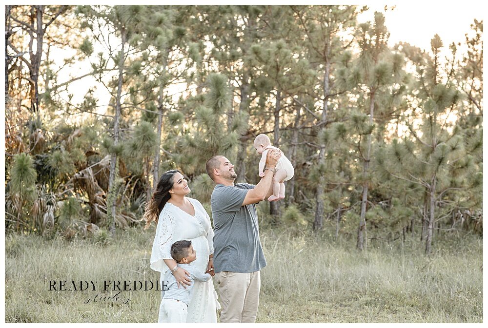 baby toss in the air for family portraits in Coral Gables | Ready Freddie Studios - Miami, FL