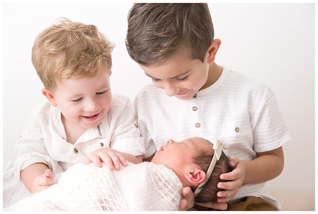 boys holding newborn sister | miami newborn photographer