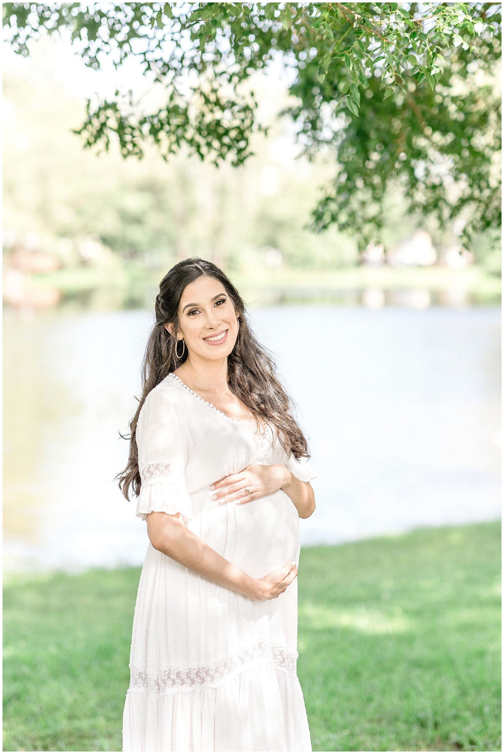 Mom smiles while holding pregnant stomach. Photos by Ivanna Vidal Photography.