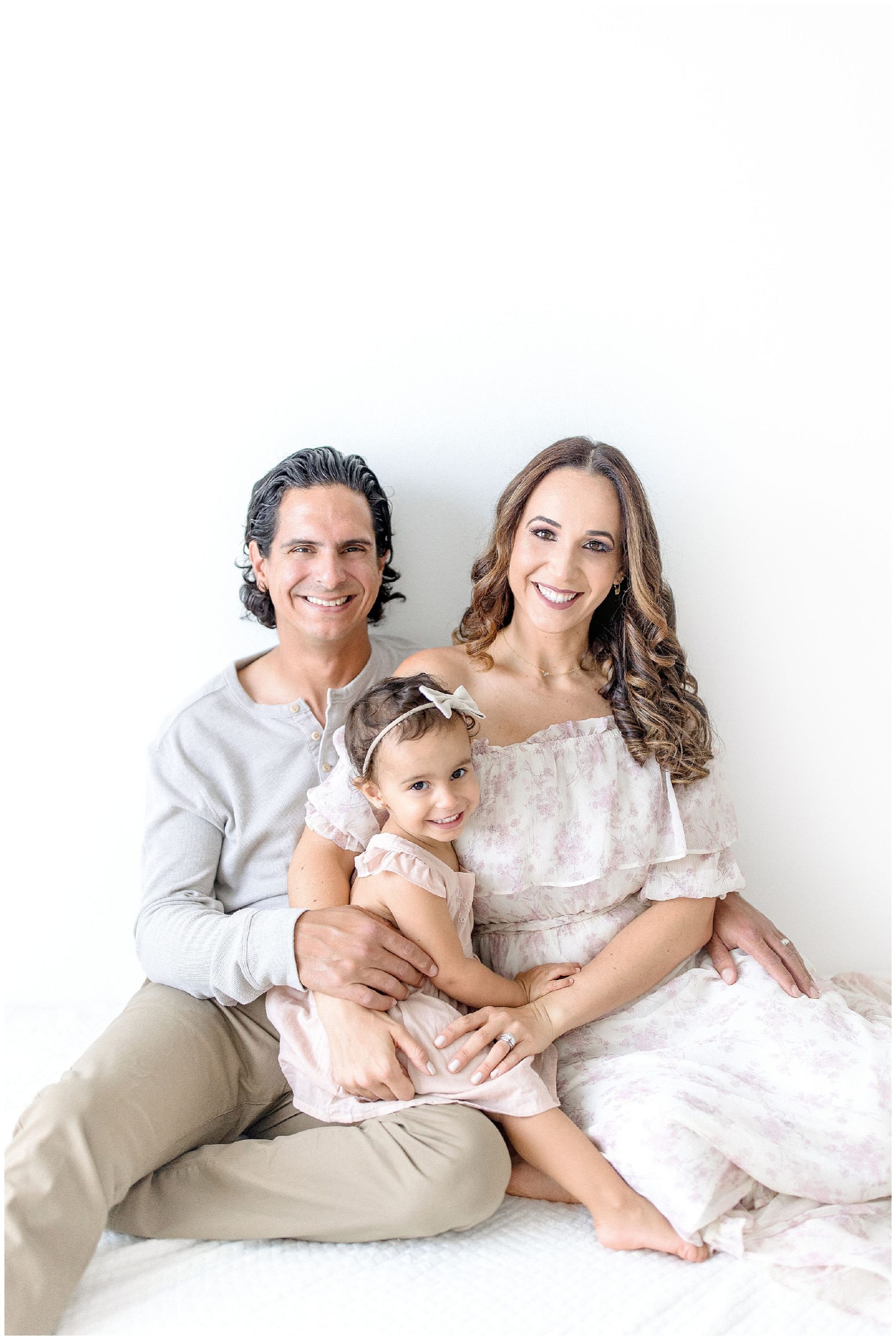 Mom & Dad smile with daughter in Miami studio. Photo by Ivanna Vidal Photography.