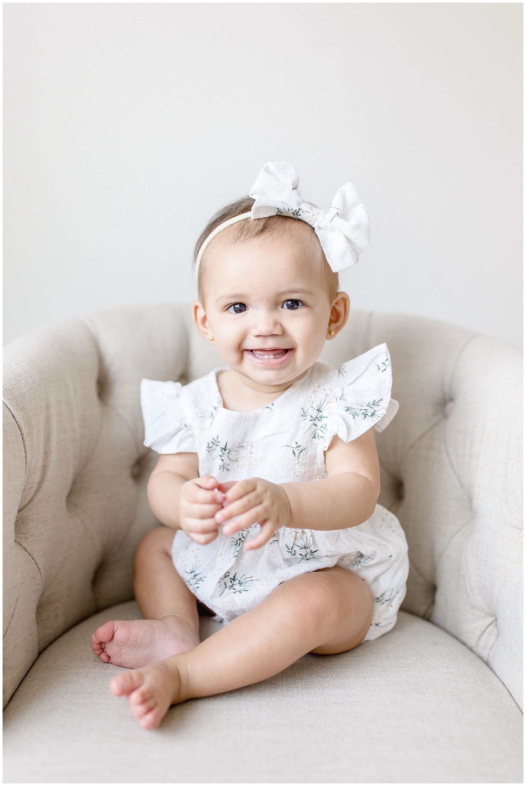 Baby girl in romper & bow. Photos by Ivanna Vidal Photography.