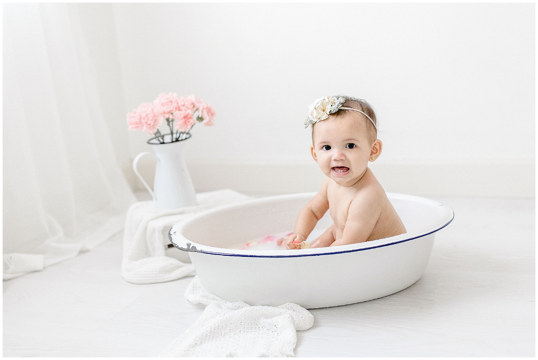 Baby girl smiles during a milk bath. Photos by Ivanna Vidal Photography.