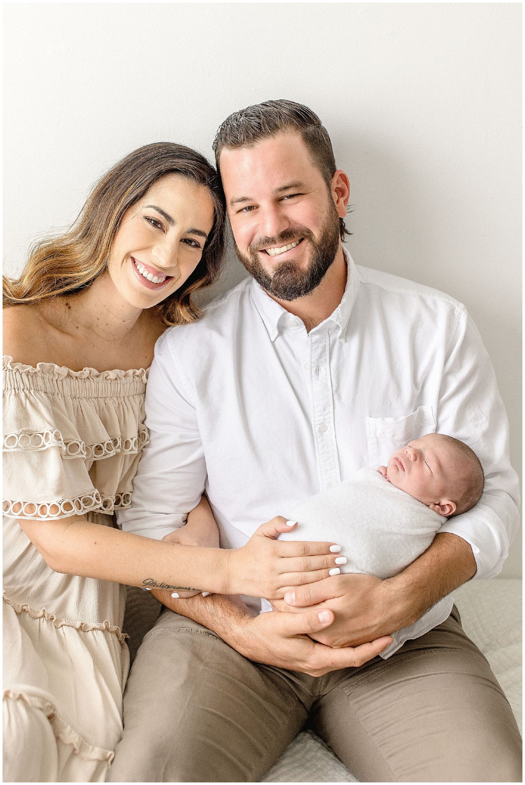 Parents hold son during South Florida newborn session. Photo by Ivanna Vidal Photography.