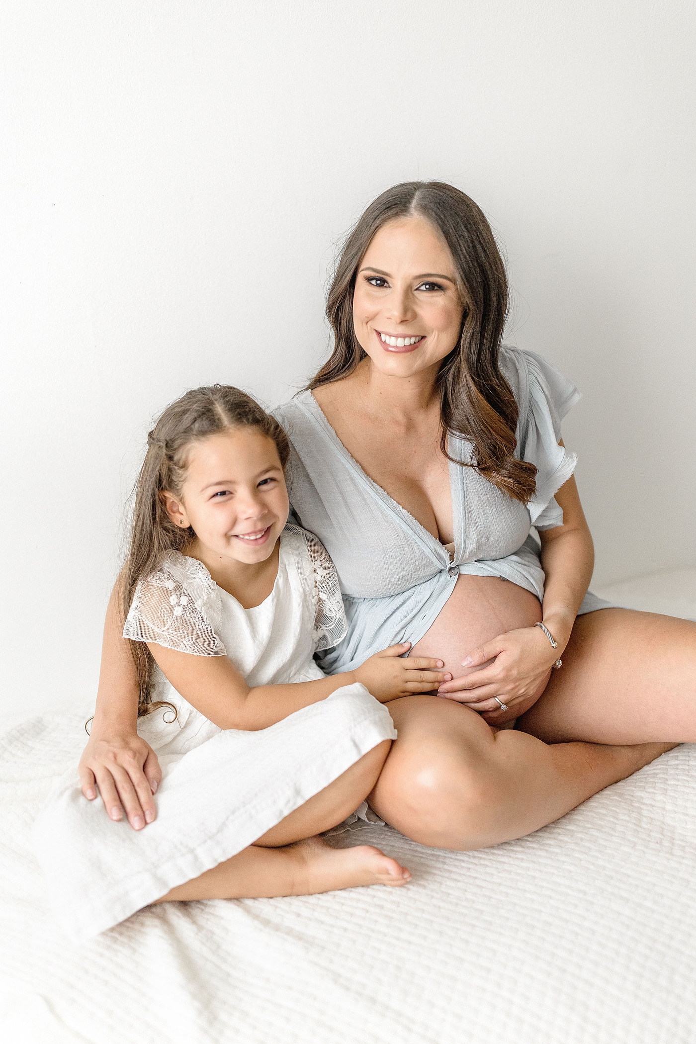 Mom and daughter smile during Miami maternity session in studio. Photo by Ivanna Vidal Photography.