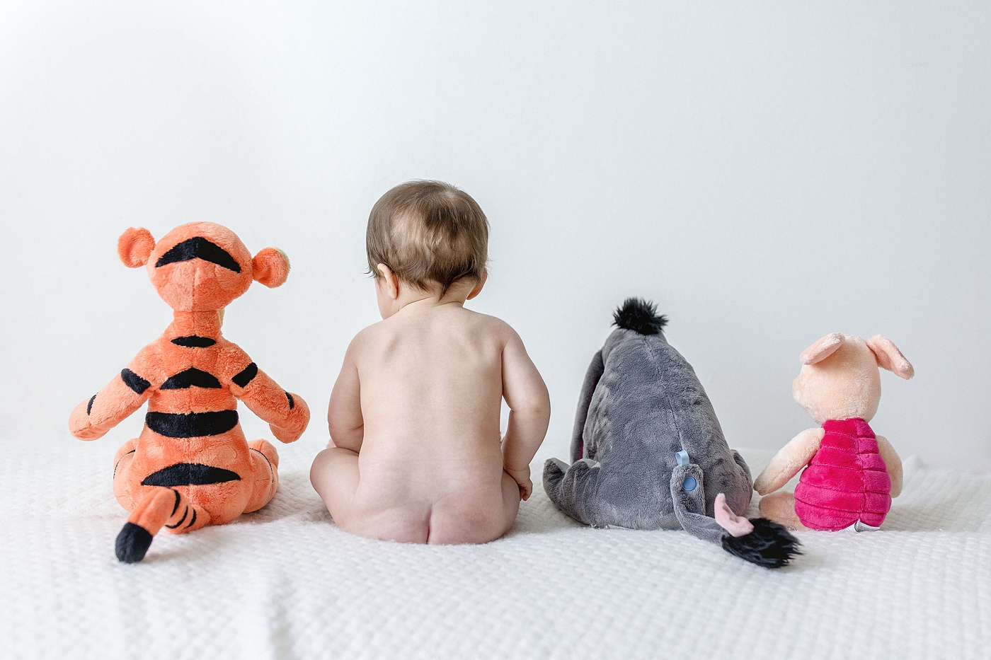 Baby boy sits with his pals from 100 Acre Woods during Miami Children Photography session. Photo by Ivanna Vidal Photography.