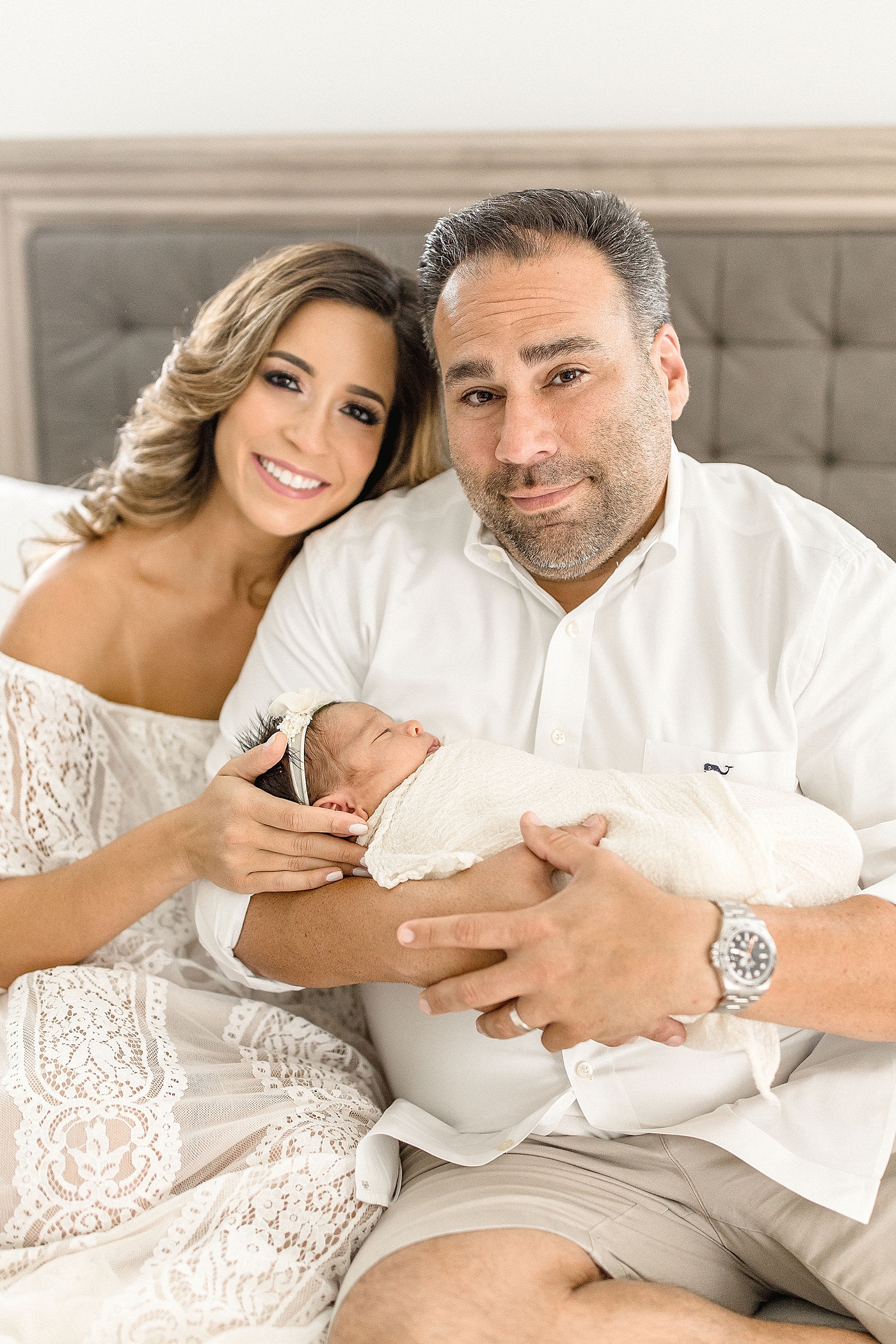 Mom & Dad smile for portrait with newborn daughter. Photo by Ivanna Vidal Photography.