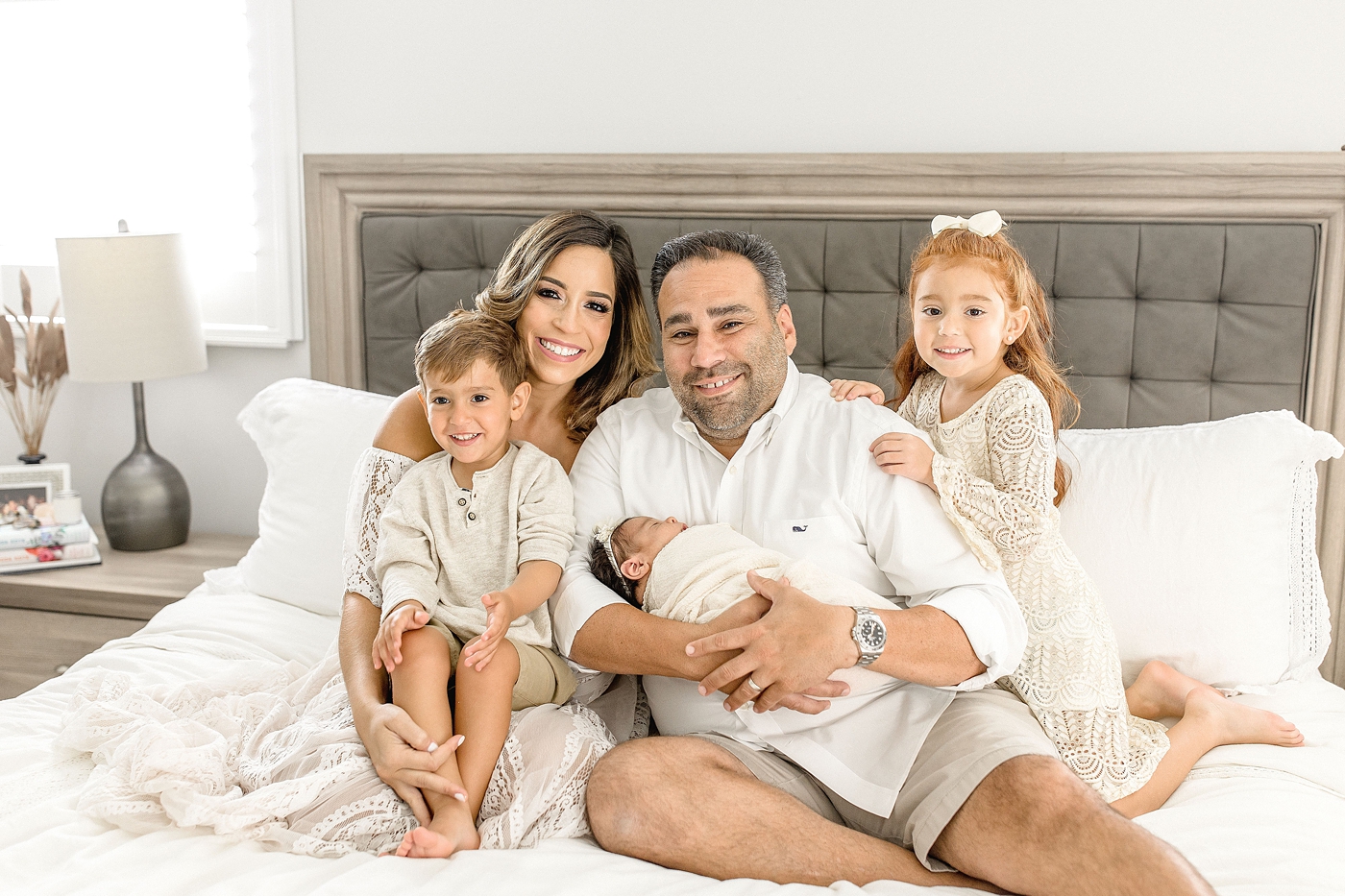 Family of five smiles for portrait during in home Newborn Photography Miami session. Photo by Ivanna Vidal Photography.