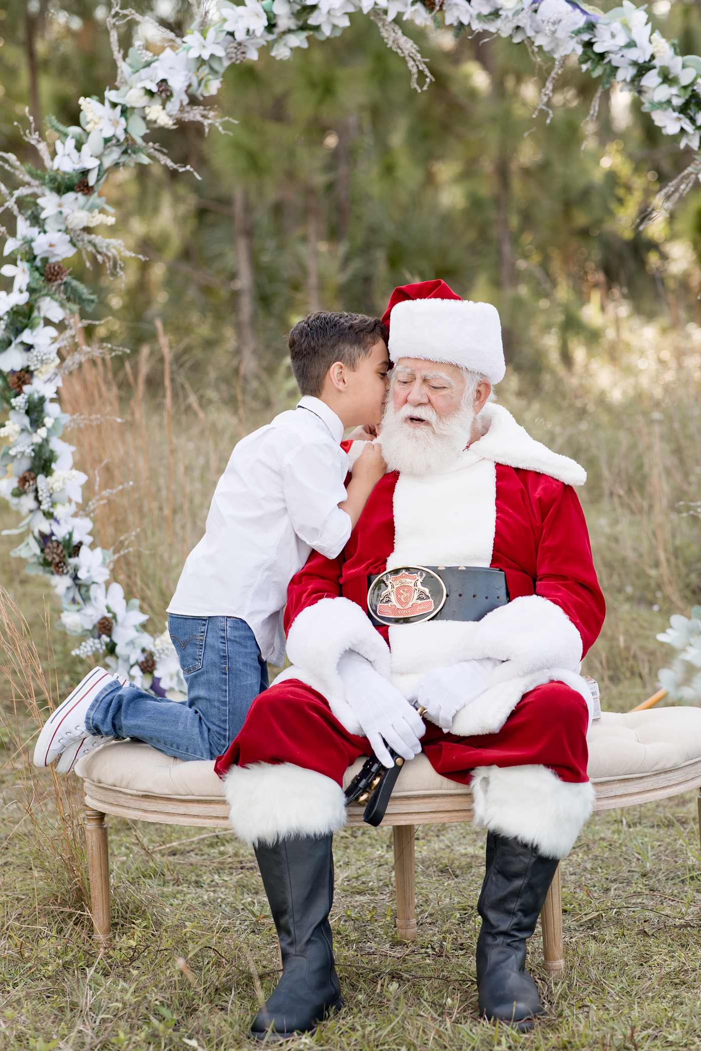Little boy whispers secret to Santa Claus during Miami Santa session. Photo by Ivanna Vidal Photography.