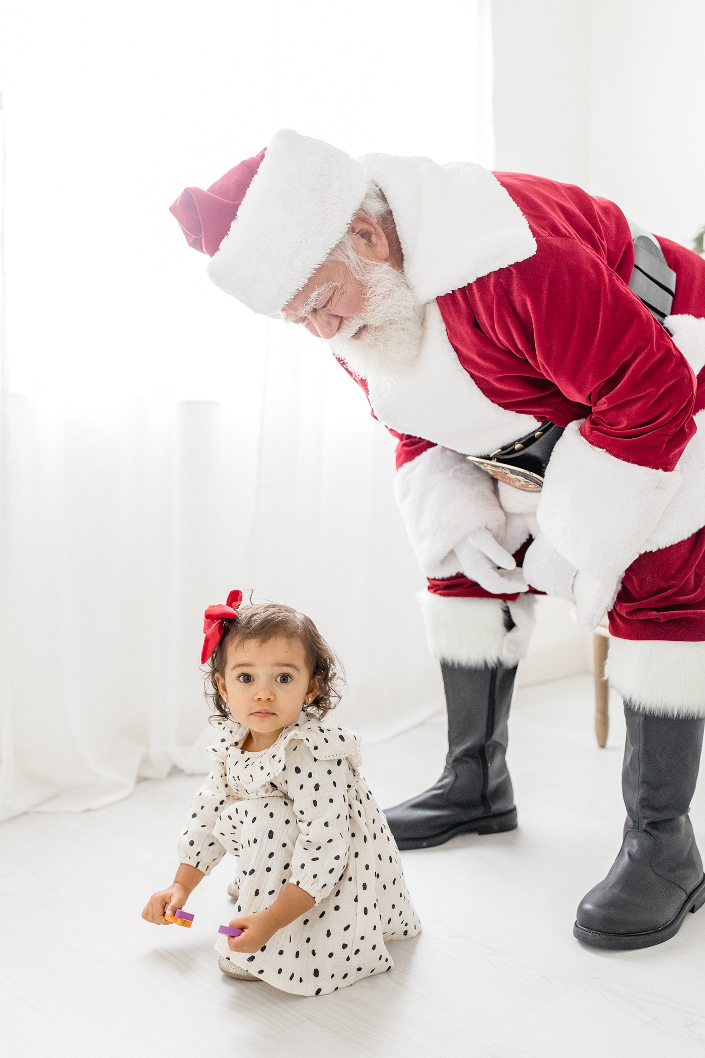 Santa Claus watches over little girl during Miami studio session. Photo by Ivanna Vidal Photography.