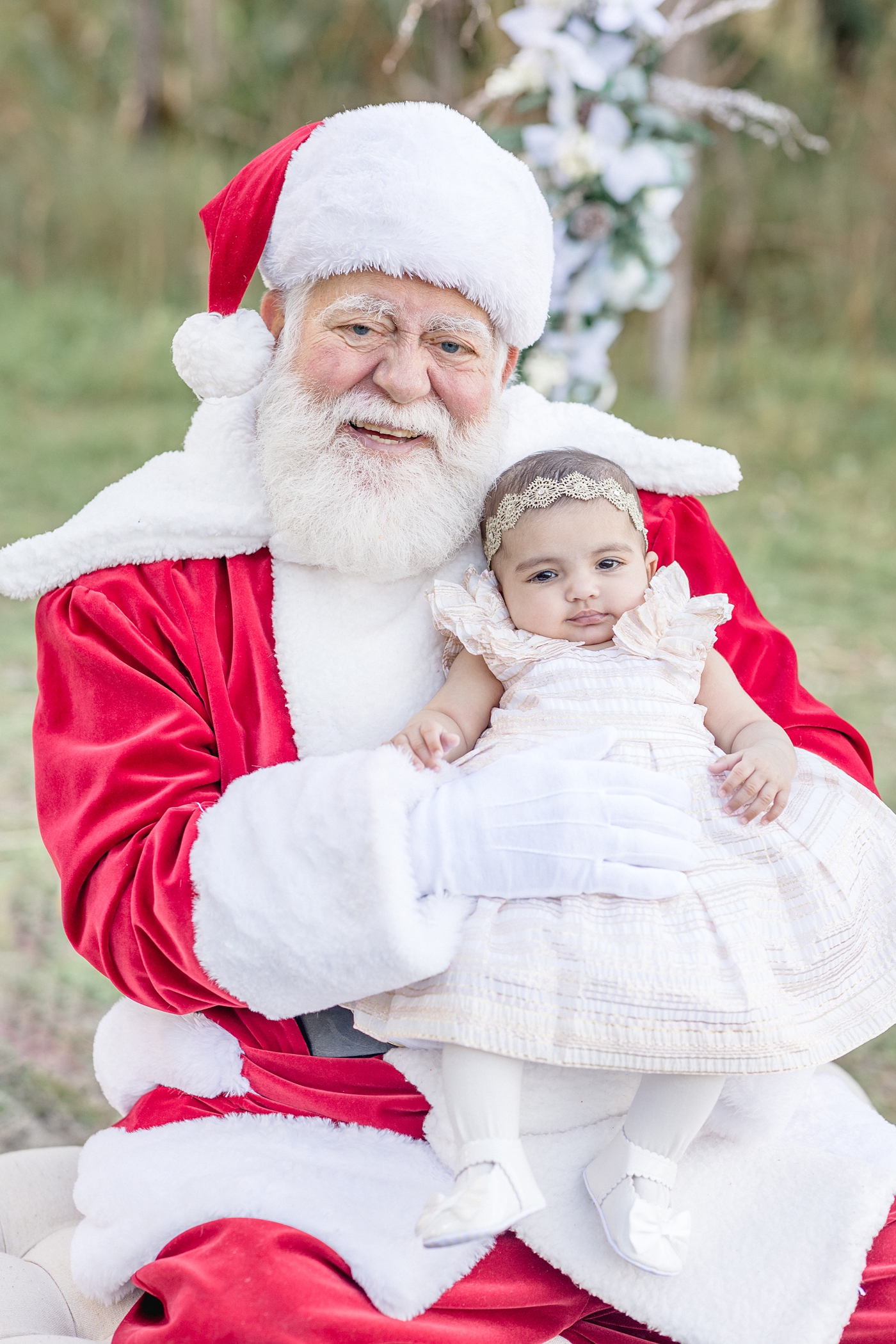 Baby girl and Santa smile for photograph. Photo by Ivanna Vidal Photography.