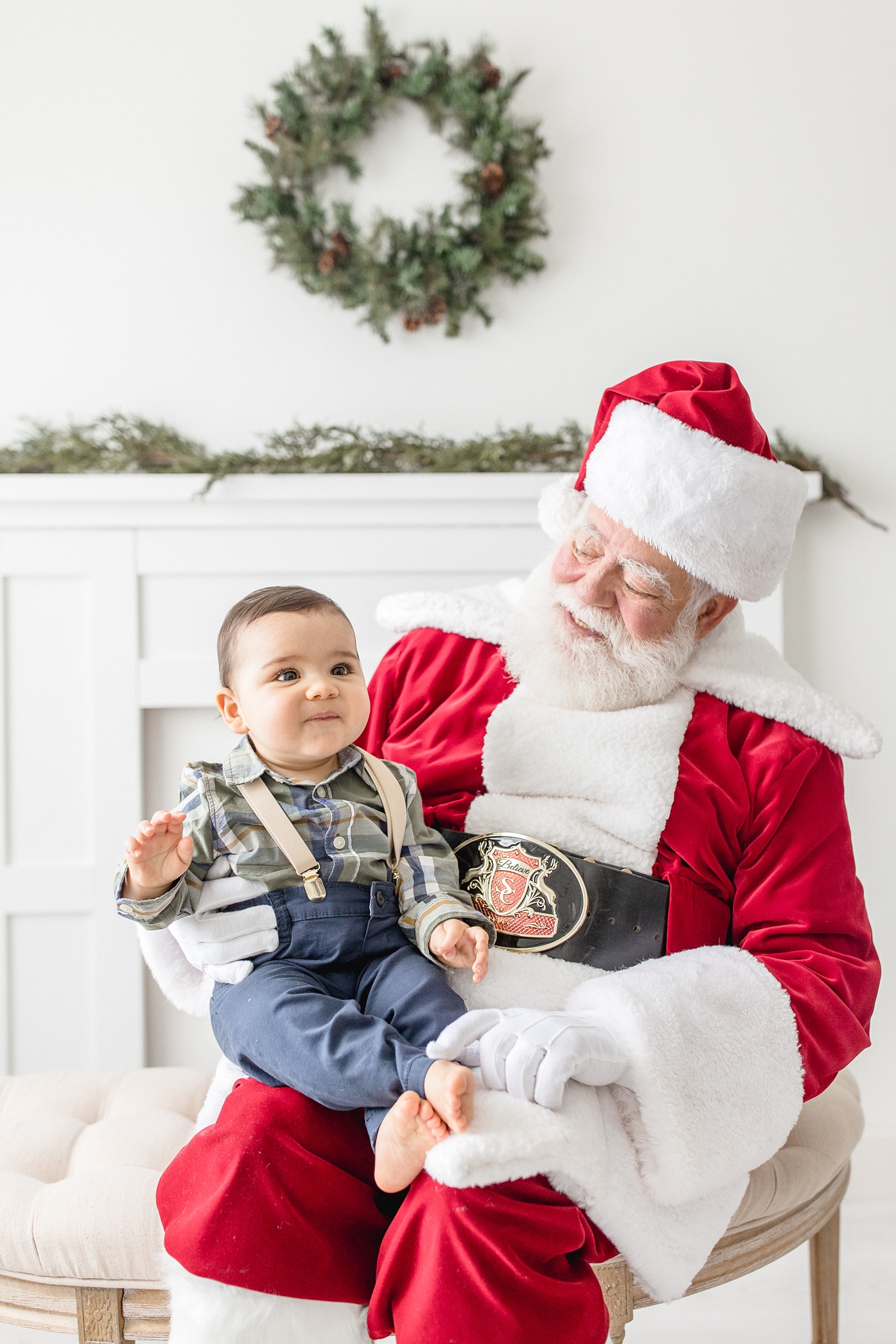 Baby boy sits in Santa Claus's lap. Photo by Ivanna Vidal Photography.