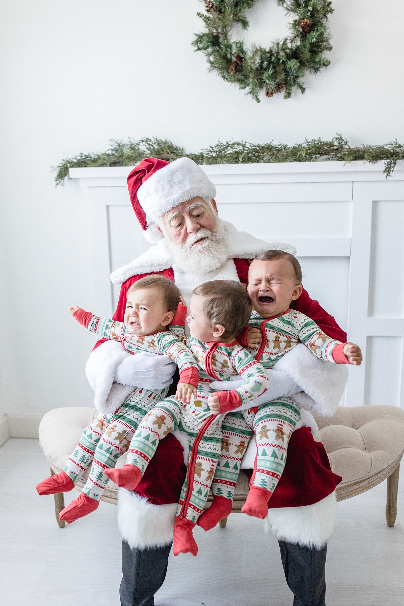 Santa Claus holds screaming triplets in miami studio session. Photo by Ivanna Vidal Photography.