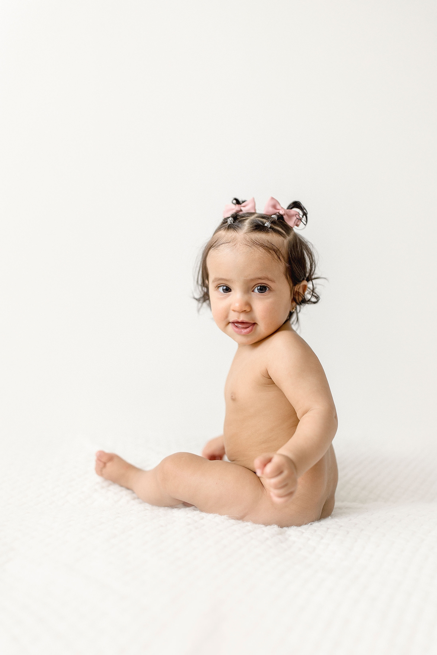 Baby girl sits unassisted during six month baby photography miami session. Photo by Ivanna Vidal Photography.
