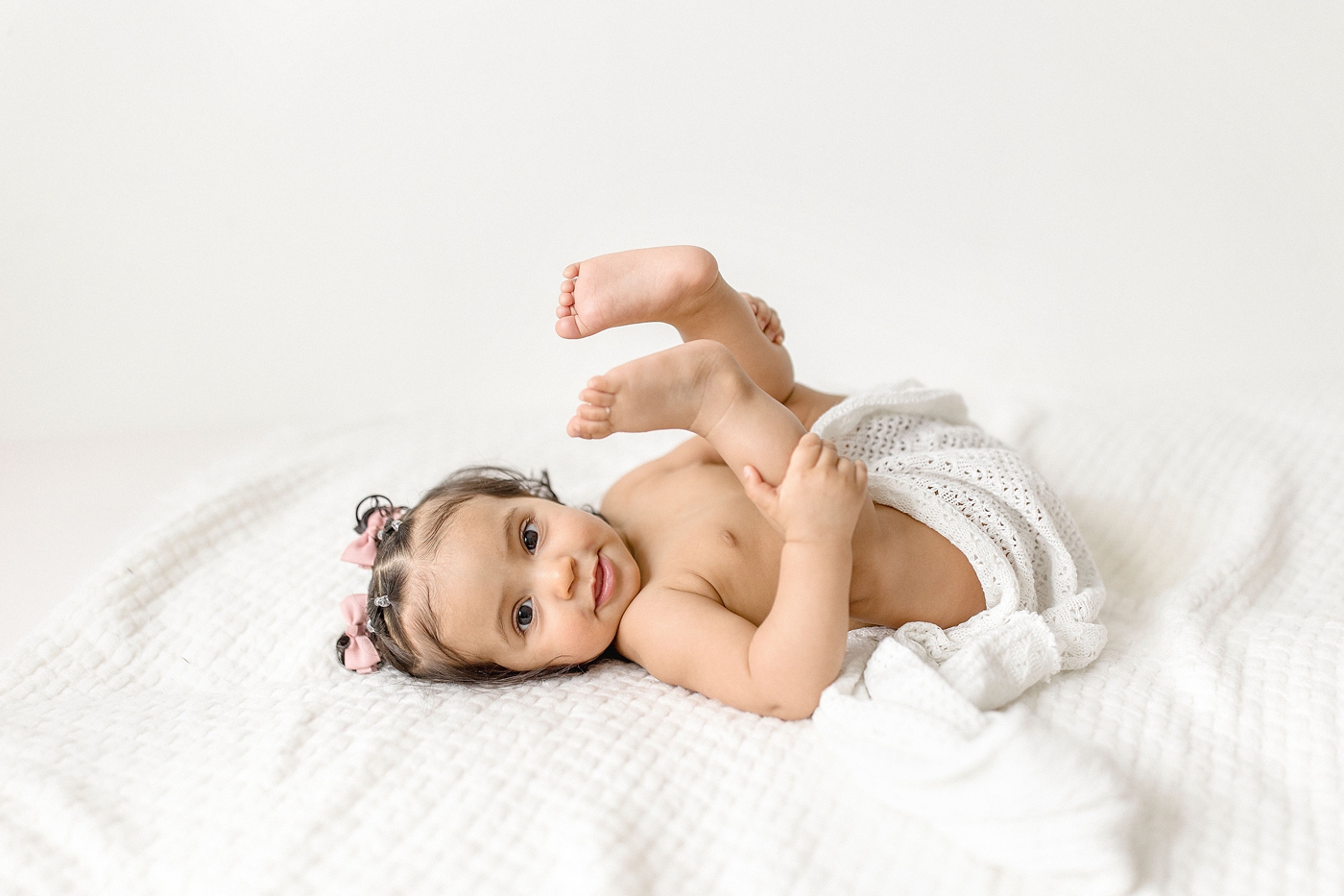 Baby girl shows off her toes during milestone baby photography miami session. Photo by Ivanna Vidal Photography.