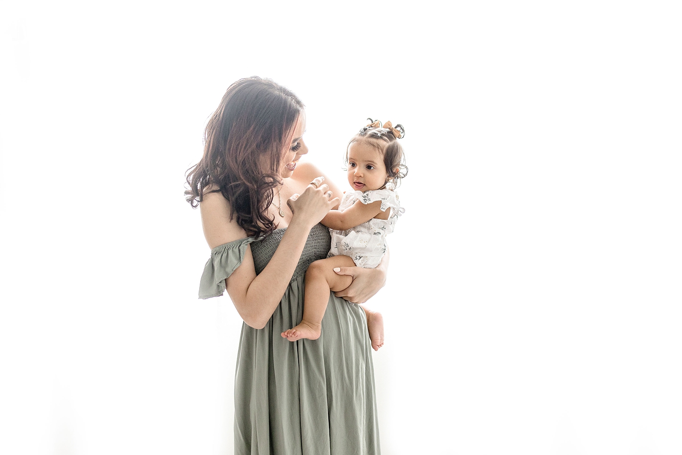 Mom holds her baby in studio during baby photography miami session. Photo by Ivanna Vidal Photography.