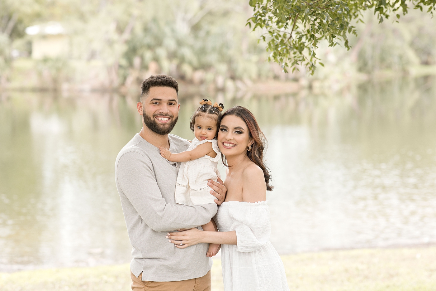 Beautiful family of three pose for a portrait during baby photography miami session. Photo by Ivanna Vidal Photography.