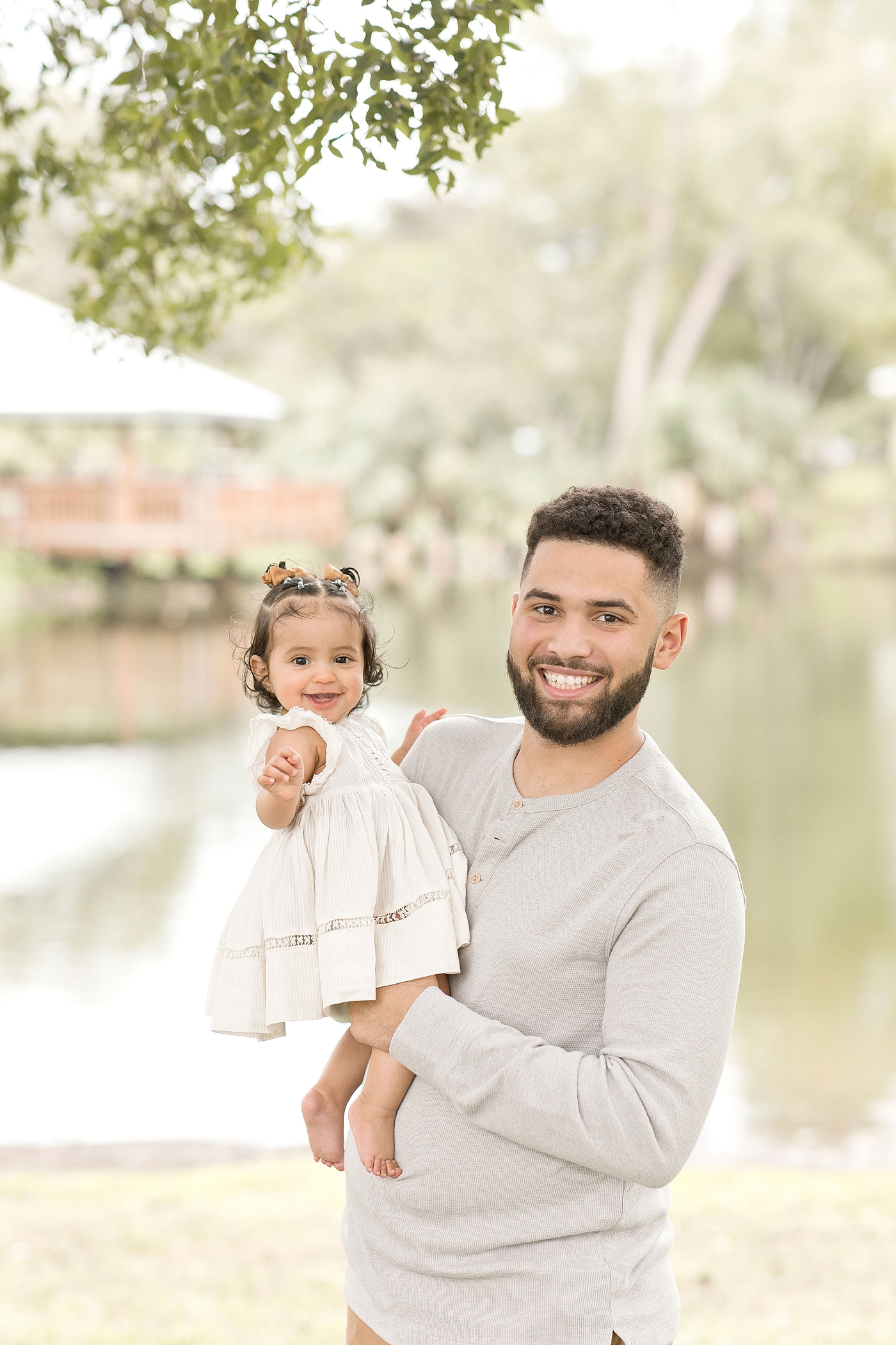 Dad holds his daughter smiling during baby photography miami session. Photo by Ivanna Vidal Photography.