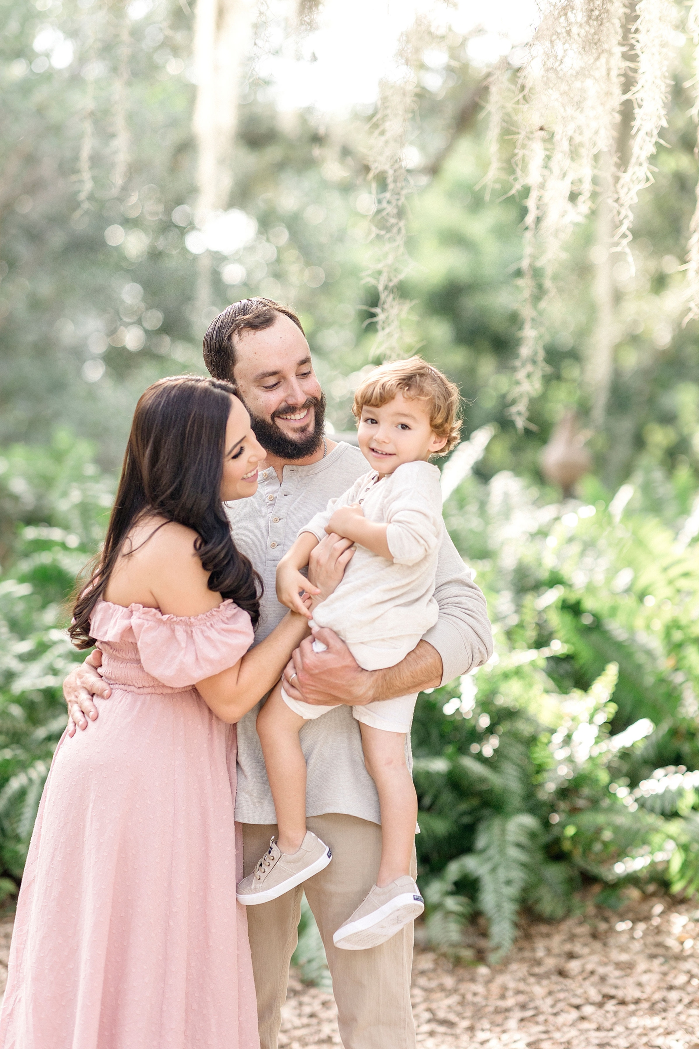 Mom and Dad snuggle into son during family photos at Vizcaya Museum and Gardens in Miami. Images by Ivanna Vidal Photography.