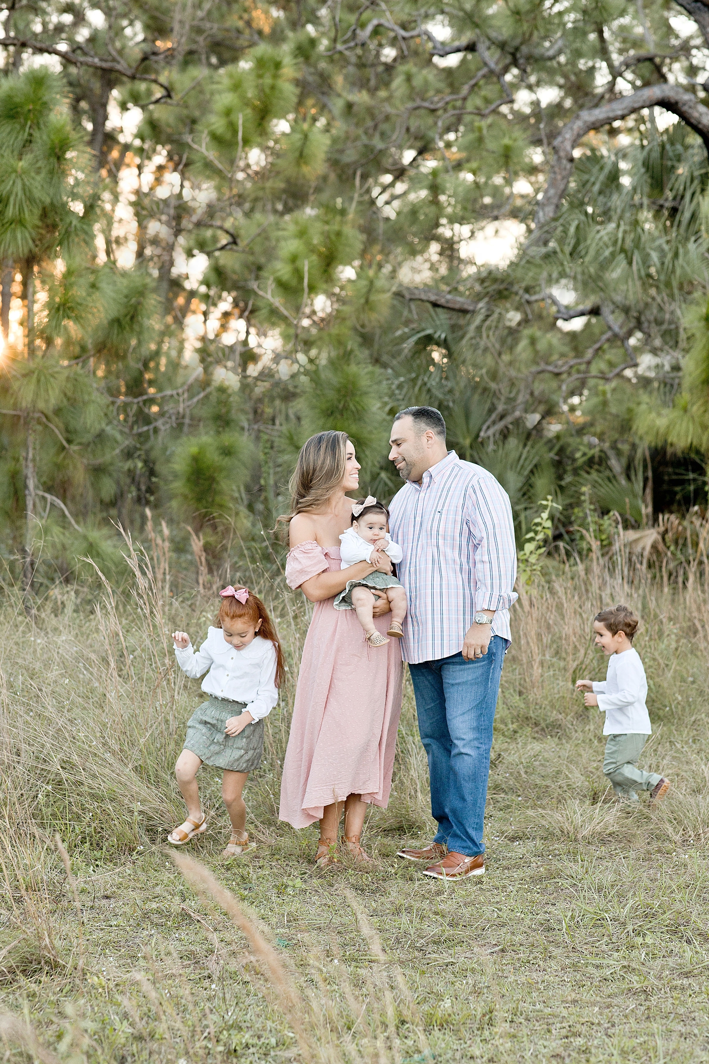 Children run in circles around their parents during Miami family photo session. Photo by Ivanna Vidal Photography.