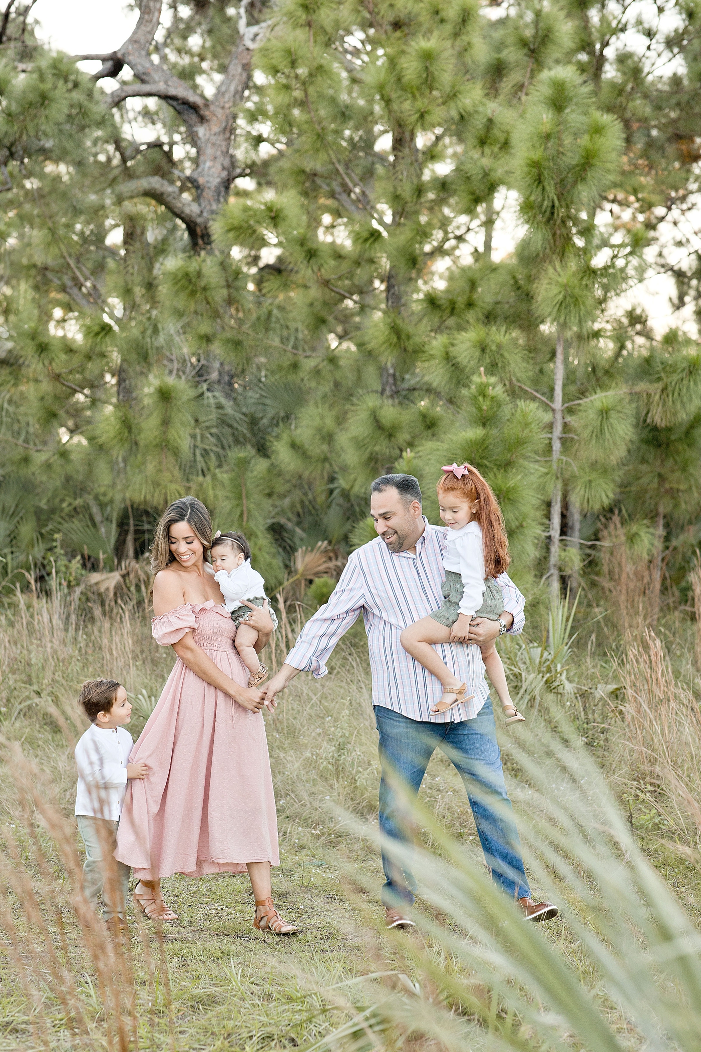Miami family strolls through field during family photo session. Photo by Ivanna Vidal Photography.