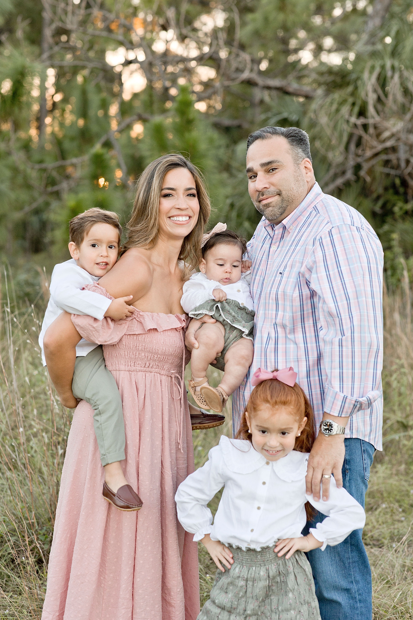 Family of five snuggle in close for photograph during Miami family session. Photo by Ivanna Vidal Photography.