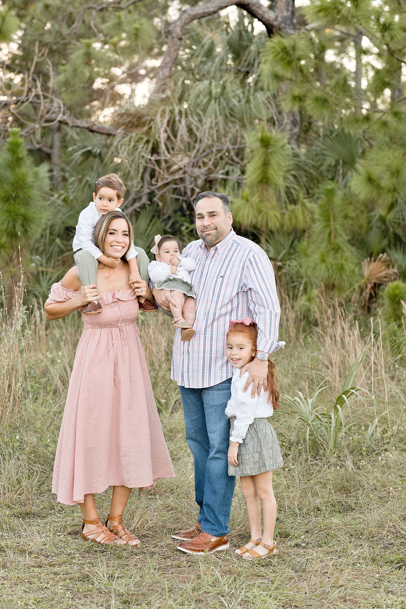 Family of five takes portrait in Miami field. Photo by Ivanna Vidal Photography.