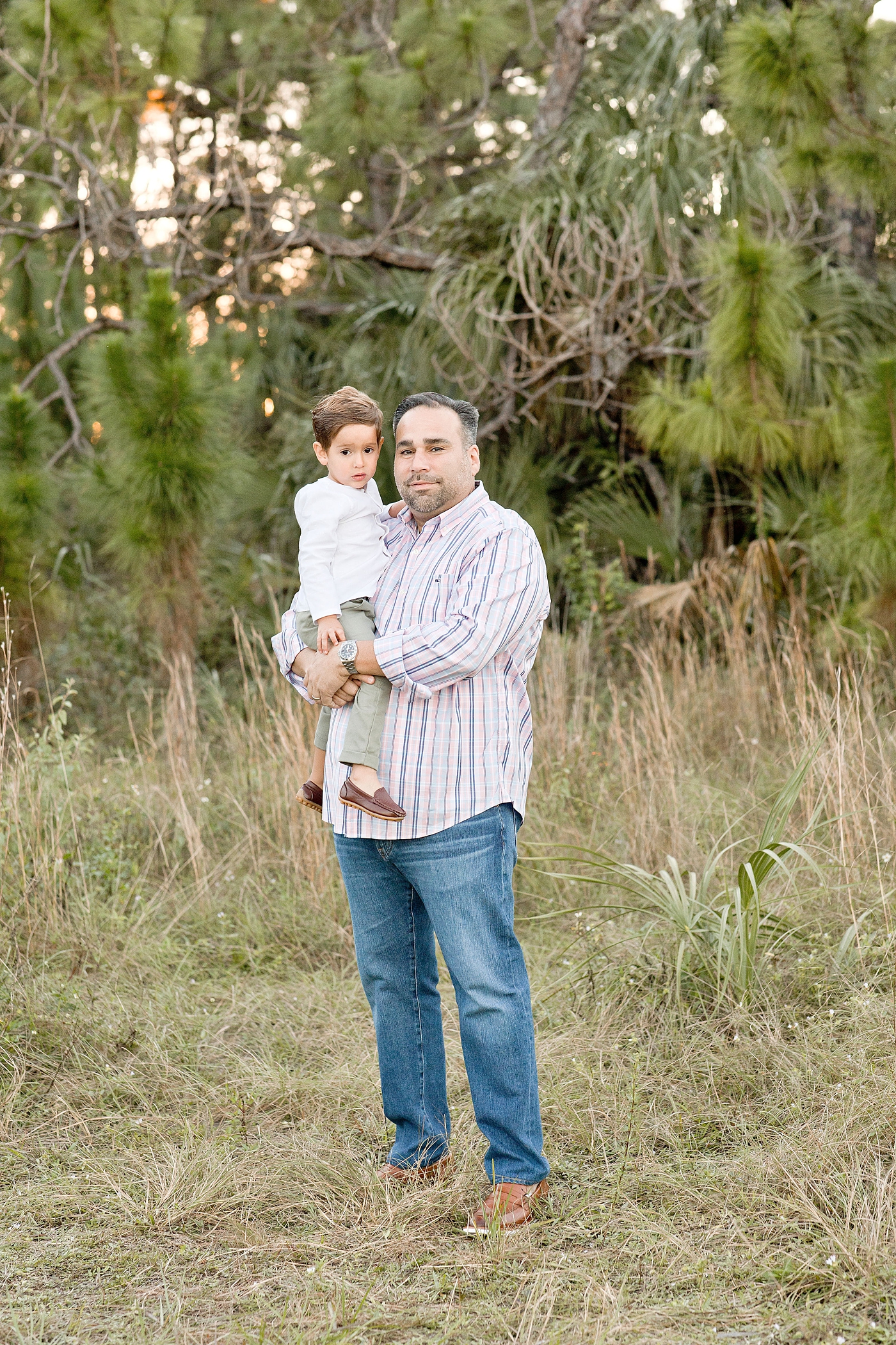 Dad holds his son in his arms for portrait. Photo by Ivanna Vidal Photography.