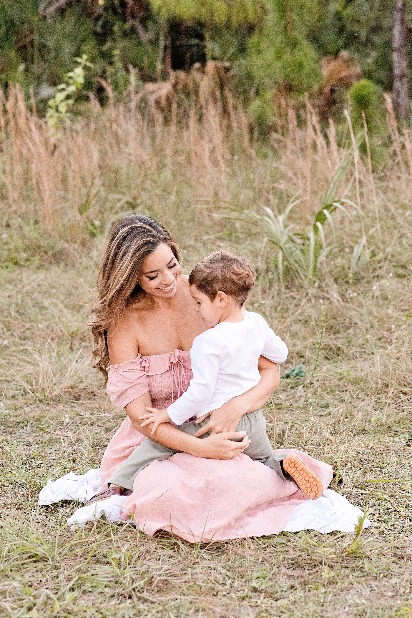 Mom and son cuddle in Miami field. Photo by Ivanna Vidal Photography.