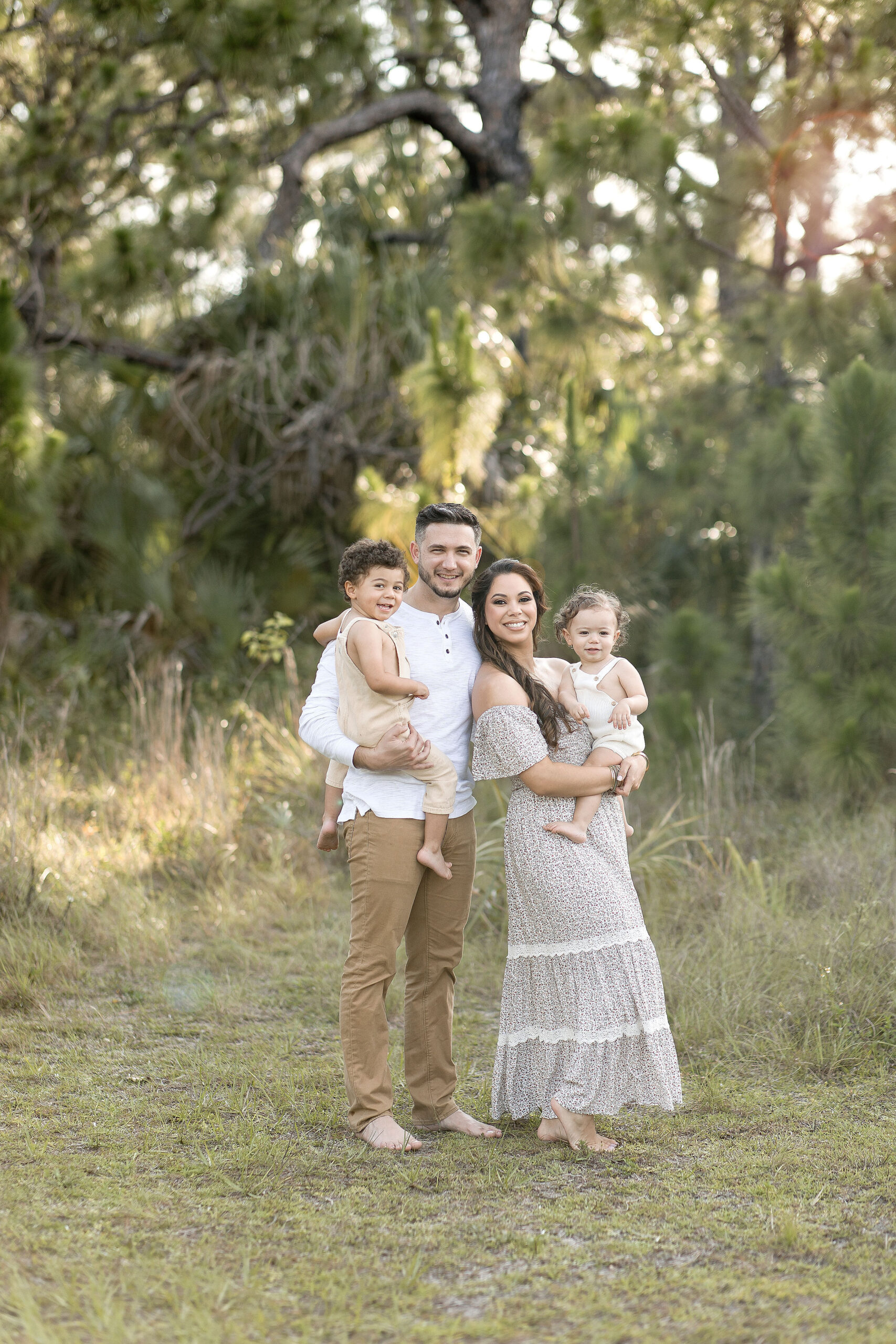 Family of four in neutral clothing in a field at sunset date night ideas in miami
