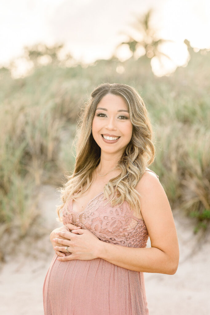 mom to be in pink maternity gown in the dunes at Crandon Park Maternity Photoshoot locations in Miami