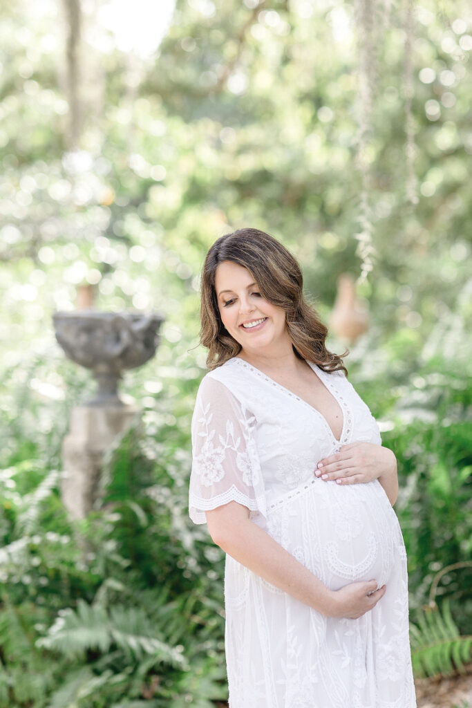 mom to be standing in the gardens at Vizcaya Museum and Gardens maternity photoshoot locations in miami