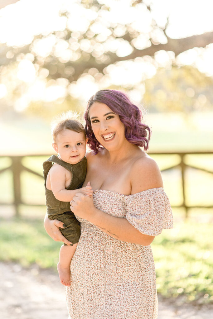 new mom with purple hair holding her new son
