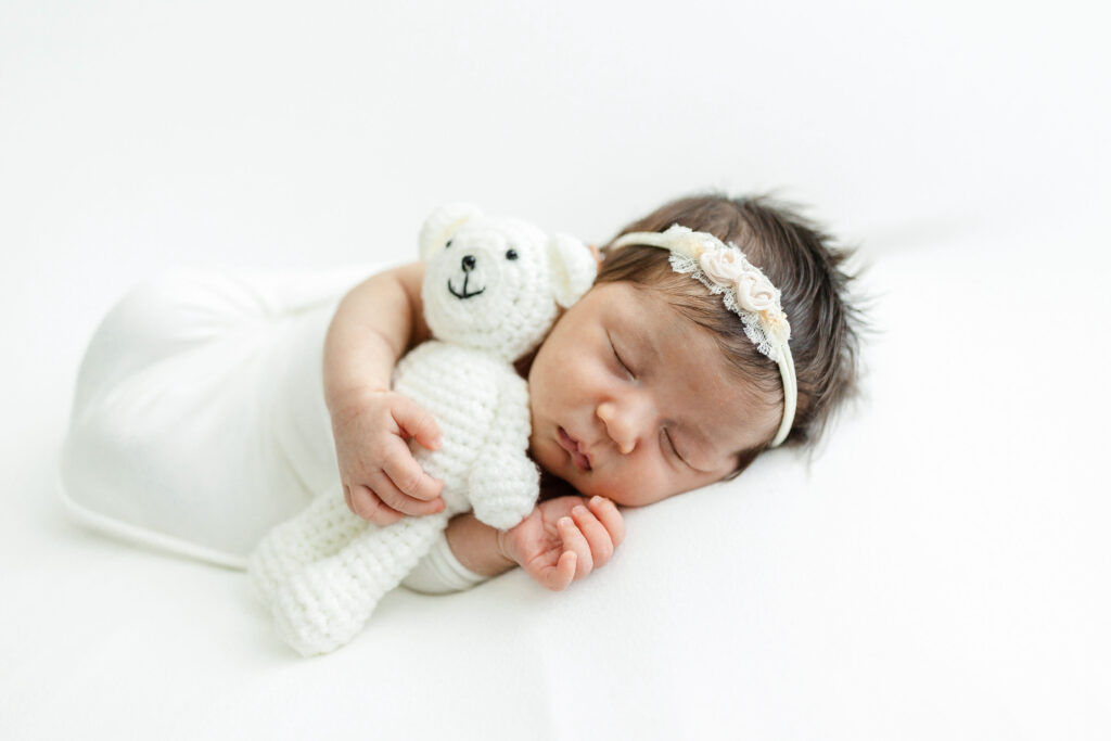 newborn baby with a white bear and headband Caprilina