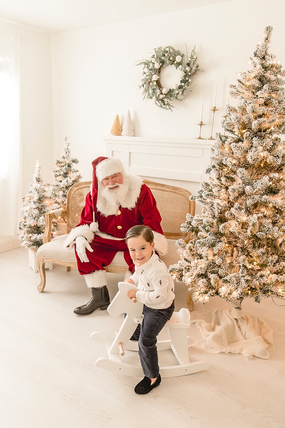 little boy on a rocking horse hanging out with Santa | Ivanna Vidal Photography The Santa Experience 