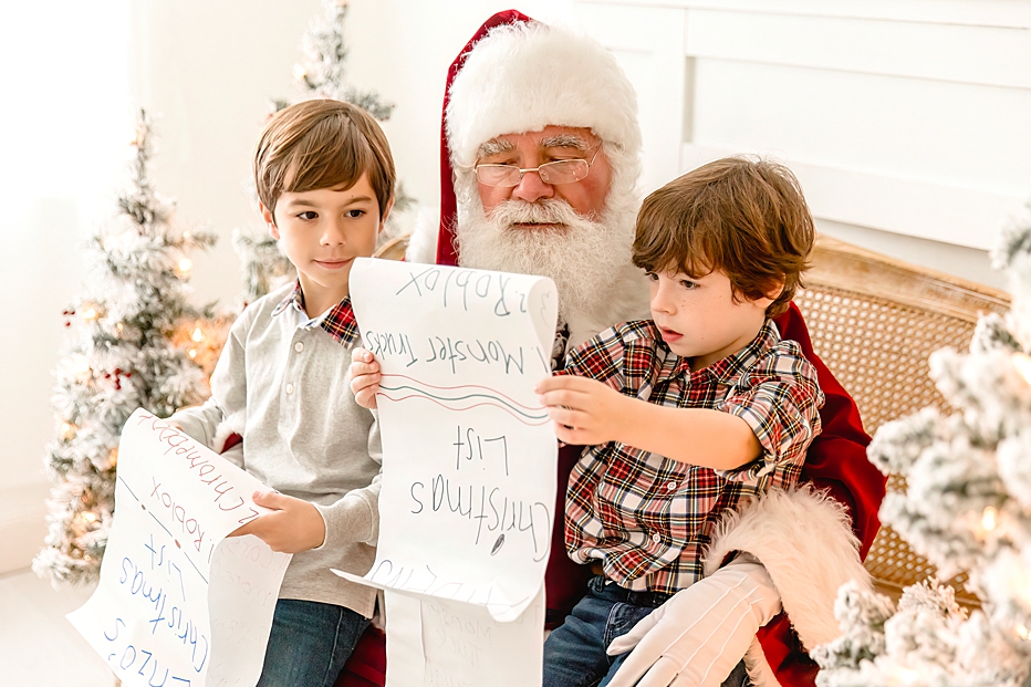 2 boys with santa looking over their wish list 