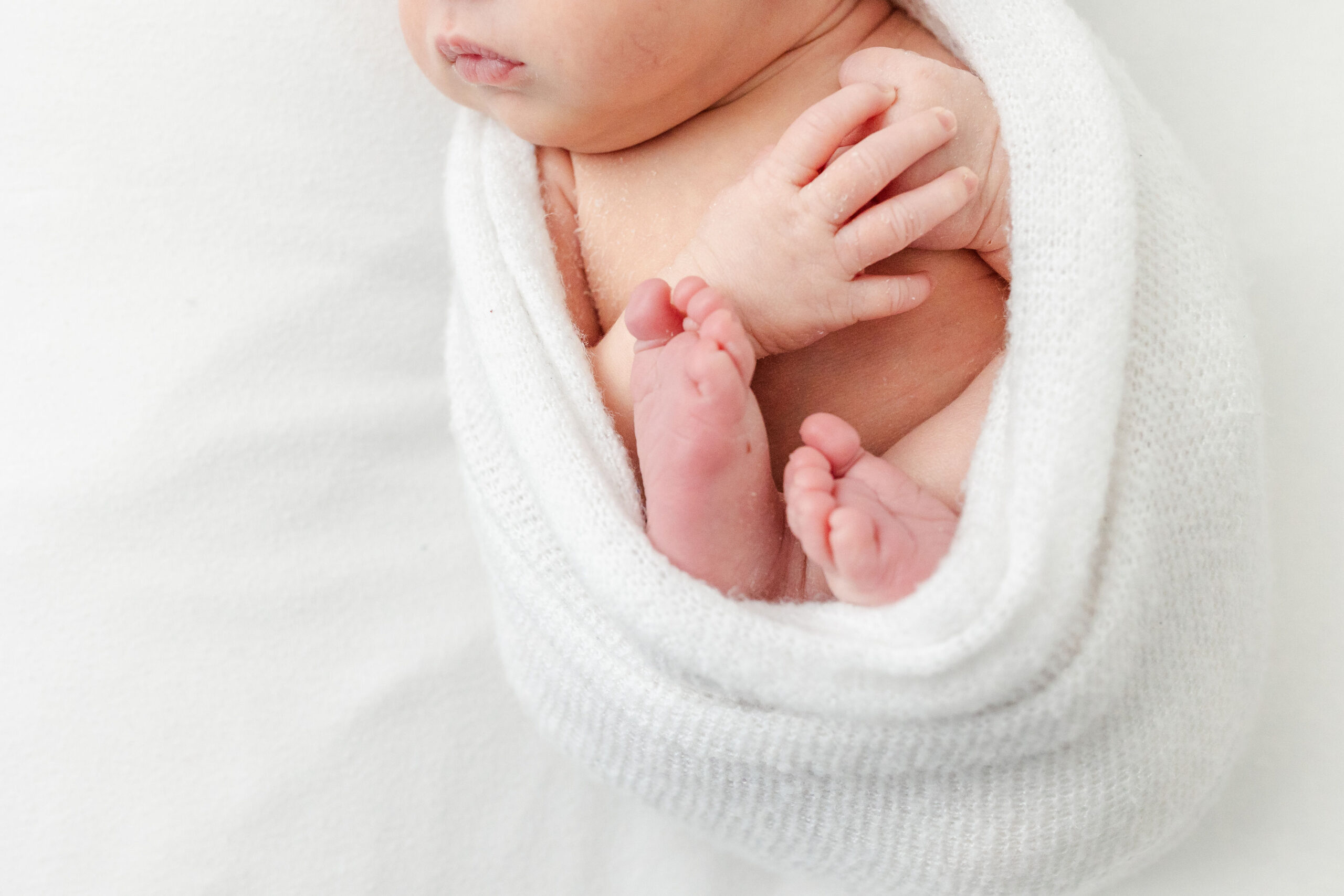 Details of a newborn baby's feet in a white swaddle after visiting bambi baby store