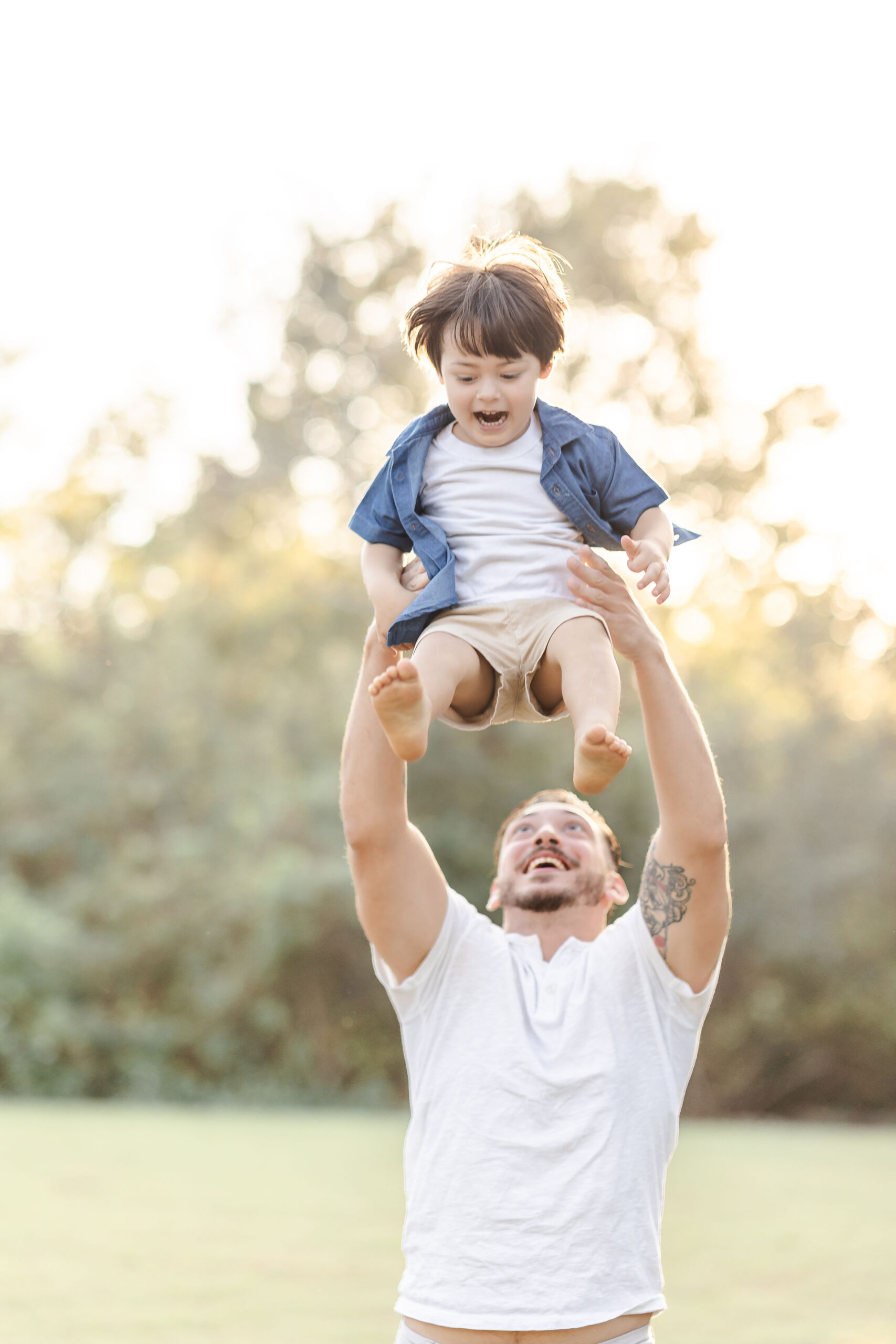 A toddler screams while dad tosses him in the air in a park at sunset before visiting fall festivals in fort lauderdale